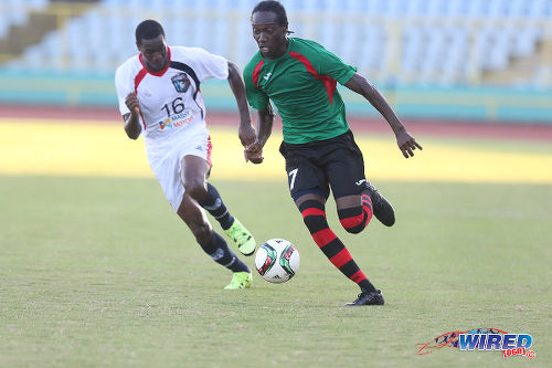 Photo: San Juan Jabloteh winger Nathan Lewis (right) races past Morvant Caledonia United right back Ordell Flemming in 2015/16 Pro League action. (Courtesy Chevaughn Christopher/Wired868