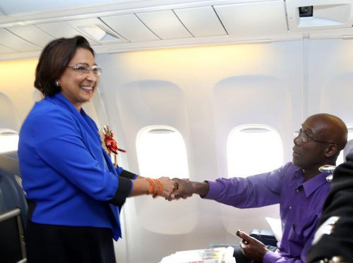 Photo: Then Prime Minister Kamla Persad-Bissessar (left) shakes hands with her successor, Dr Keith Rowley, en route to Nelson Mandela's funeral in South Africa. (Courtesy News.Gov.TT)