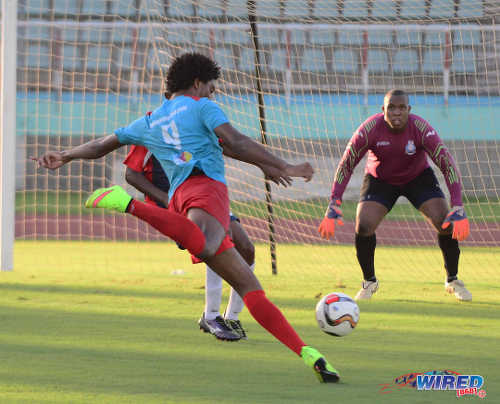 Photo: Marabella Family Crisis Centre striker Juma Clarence prepares to strike the ball while Police FC goalkeeper Theon Browne (right) looks on during NSL action. (Courtesy DPI Photography/Wired868)