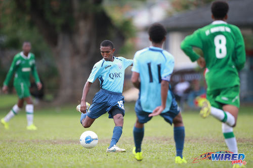 Photo: QRC attacker John-Paul Rochford (centre) takes a crack at goal during 2015 SSFL action against St Augustine Secondary. Rochford is expected to be a key member of the Trinidad and Tobago National Under-17 Team. (Courtesy Allan V Crane/Wired868)