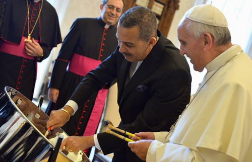 Photo: Trinidad and Tobago President Anthony Carmona (second from right) shows Pope Francis how to beat iron. (Courtesy whensteeltalks.com)