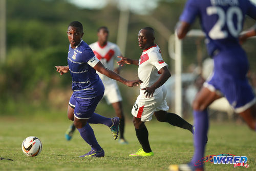 Photo: Defence Force captain Chris Durity (left) looks for passing options while Tobago FC Phoenix 1976 player Onasi Forde (centre) looks on during 2015/16 CNG National Super League action at the Canaan Recreational Grounds, Tobago. (Courtesy Allan V Crane/Wired868)