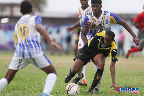 Photo: St Benedict's College attacker Marlon Phillip (right) tries to find a way through the Fatima College defence during 2015 SSFL action. (Courtesy Chevaughn Christopher/Wired868)