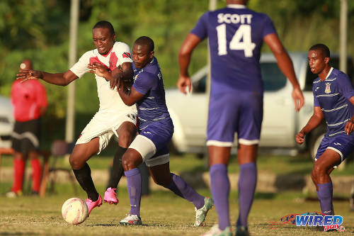 Photo: Tobago FC Phoenix 1976 attacker Lejandro Williams (left) tries to hold off a Defence Force player during 2015/16 CNG National Super League action at the Canaan Recreational Grounds, Tobago. (Courtesy Allan V Crane/Wired868)