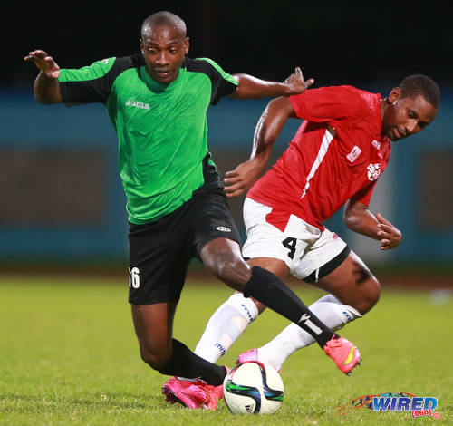 Photo: Prisons FC's Lance Haynes (left) tries to escape from Petrotrin Palo Seco's Wilian Garcia in 2015 CNG NSL KO semifinal action. (Courtesy Kerlon Orr/Wired868)