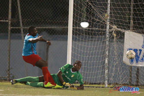 Photo: FC Santa Rosa goalkeeper Kitwana Manning (right) looks on as the ball bounces wide, after a reflex stop from Marabella Family Crisis Centre captain Ghymo Harper during 2015/16 NSL Premiership Division. (Courtesy Allan V Crane/Wired868)