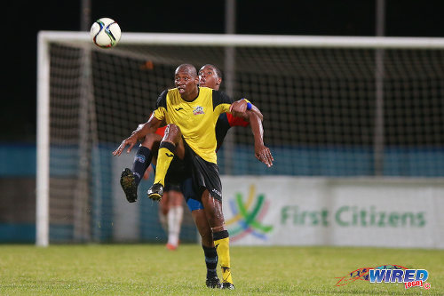 Photo: Club Sando striker Kevon "Showtime" Woodley holds off a Morvant Caledonia United defender during the 2015 First Citizens Cup third place play off. (Courtesy Allan V Crane/Wired868)