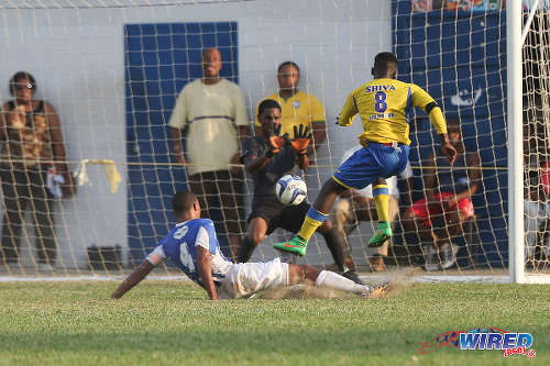 Photo: Shiva Boys HC left back Isaiah Garcia (right) blasts a shot at goal while St Mary's College goalkeeper Kristopher Donaldson (centre) prepares to save during the 2015 SSFL season. (Courtesy Chevaughn Christopher/Wired868)