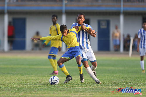 Photo: Shiva Boys HC midfielder Mark Ramdeen (left) holds off St Mary's College player and fellow substitute Joshua Joseph during 2015 SSFL action. (Courtesy Chevaughn Christopher/Wired868)