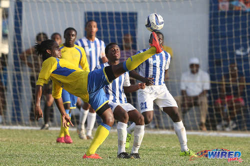 Photo: Shiva Boys HC mdifielder Yohannes Richardson (left) controls the ball while St Mary's College forward Chinua Bernard looks on during 2015 SSFL action at Serpentine Road. (Courtesy Chevaughn Christopher/Wired868)