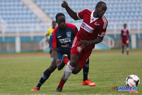 Photo: Central FC defender Andre Ettienne (right) gets to the ball before a Morvant/Caledonia United player during 2015 Toyota Classic quarterfinal action. (Courtesy Chevaughn Christopher/Wired868)