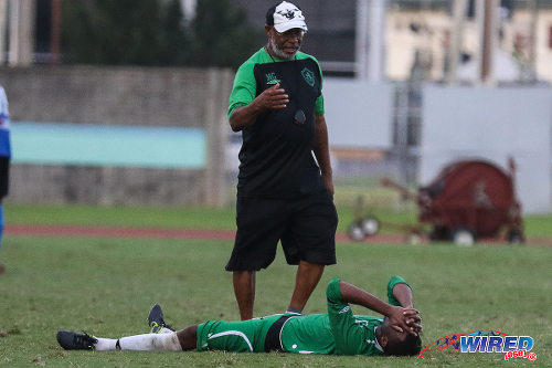 Photo: St Augustine Secondary coach Michael Grayson (standing) tries to console defensive midfielder Ainsworth Grant, after their 2-1 loss to Naparima College in the 2015 National Intercol final at the Mannie Ramjohn Stadium. Grayson has been replaced by Adrian Romain for the 2016 season. (Courtesy Chevaughn Christopher/Wired868)