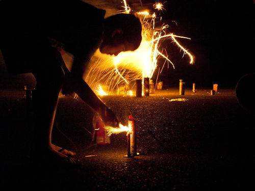 Photo: A youngster prepares to light fireworks. (Courtesy Flickr)