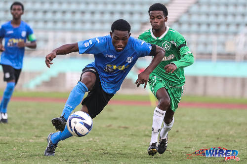 Photo: Naparima College attacker Akinola Gregory (left) motors forward under the watchful eye of St Augustine Secondary defender Kendell Boneo in the 2015 National Intercol semifinal. (Courtesy Chevaughn Christopher/Wired868)