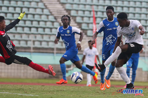 Photo: Naparima College forward Isaiah Hudson (right) fires past Presentation College (San Fernando) goalkeeper Ishmael Salaam during the 2015 South Intercol final in Marabella. (Courtesy Chevaughn Christopher/Wired868)