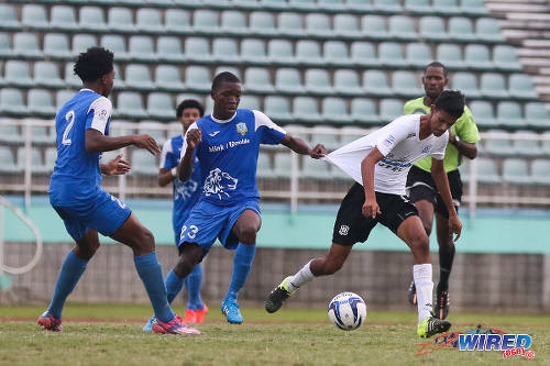 Photo: Presentation College (San Fernando) midfielder Kori Cupid (centre) tries to tug back Naparima College playmaker Justin Sadoo (right) during the 2015 South Intercol final in Marabella. (Courtesy Chevaughn Christopher/Wired868)