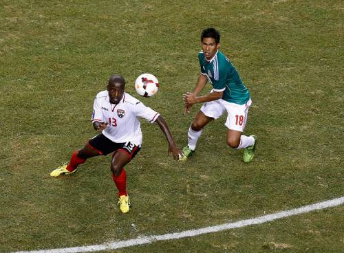 Photo: Trinidad and Tobago attacker Cornell Glen (left) tries to elude a Mexico player during the 2003 CONCACAF Gold Cup. (Courtesy CONCACAF)