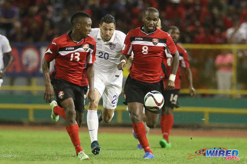 Photo: United States defender Geoff Cameron (centre) tries to keep up with Trinidad and Tobago midfielders Khaleem Hyland (right) and Cordell Cato during 2018 World Cup qualifying action at the Hasely Crawford Stadium. (Courtesy Chevaughn Christopher/Wired868)