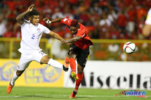 Photo: Trinidad and Tobago winger Joevin Jones (right) gets a shot off under pressure from United States midfielder DeAndre Yedlin during a goalless draw at the Hasely Crawford Stadium in 2018 World Cup qualifying action on 17 November 2015. (Courtesy Allan V Crane/Wired868)