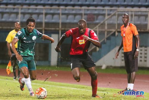 Photo: San Juan Jabloteh forward Jamal Gay (right) tries to race clear of DIRECTV W Connection defender Gerard Williams (left) during 2015/16 Pro League action in Couva. Looking on is Jabloteh assistant coach Nigel Henry. (Courtesy Chevaughn Christopher/Wired868)