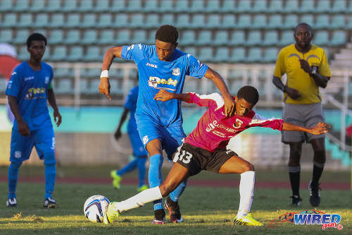 Photo: Naparima College striker Isaiah Hudson (left) brushes St Anthony's College midfielder Shem Clauzel off the ball during the 2015 National Intercol final. (Courtesy Chevaughn Christopher/Wired868)