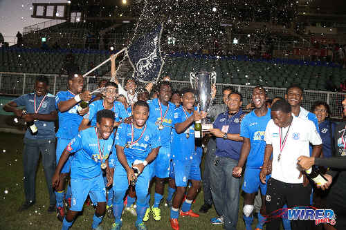 Photo: Naparima College star Jared Dass (centre) has his hand on the 2015 National Intercol trophy as the southern schoolboys celebrate at the Mannie Ramjohn Stadium. (Courtesy Chevaughn Christopher/Wired868)