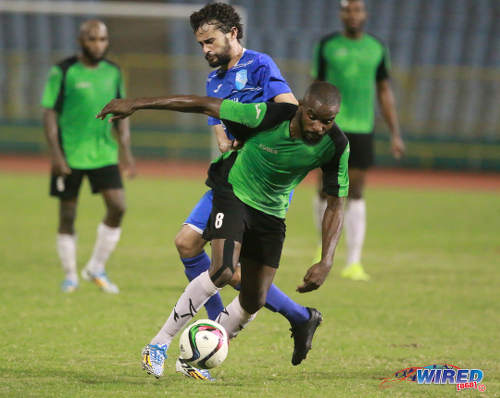 Photo: Prisons FC winger Ricardo Alleyne (foreground) keeps the ball from QPCC forward Benedict Barrett during a decisive 2015/16 CNG National Super League (NSL) Championship Division affair at the Hasely Crawford Stadium. (Courtesy Nicholas Bhajan/Wired868)