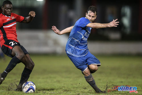 Photo: QPCC winger Jason Devenish (right) tries to elude UTT defender Ellis Roberts during 2015 CNG NSL Championship Division action at UTT Grounds, Arima. (Courtesy Allan V Crane/CA-images/Wired868)