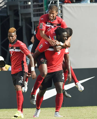 Photo: Trinidad and Tobago captain Kenwyne Jones (right) gives Radanfah Abu Bakr and another teammate a ride after scoring against Panama in the 2015 CONCACAF Gold Cup quarterfinal round. Looking on is Joevin Jones (left). (Copyright AFP 2015/Jewel Samad)