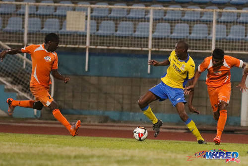 Photo: Defence Force attacker Hashim Arcia (centre) takes on Club Sando players Amritt Gildharry (right) and Devon Modeste during 2015/16 Pro League action in Couva. (Courtesy Chevaughn Christopher/Wired868)