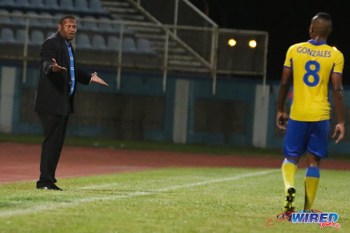 Photo: Defence Force coach Marvin Gordon (left) reacts to a late penalty kick awarded by referee Dennis Changiah during Pro League action against Club Sando at the Ato Boldon Stadium in Couva. Looking on is Defence Force player Curtis Gonzales. (Courtesy Chevaughn Christopher/Wired868)