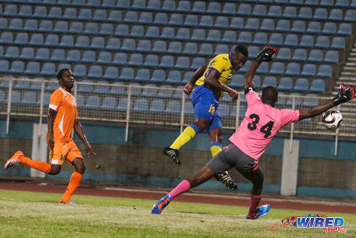 Photo: Defence Force midfielder Sean Narcis (centre) heads past Club Sando goalkeeper Kelvin Henry (right) while Devon Modeste looks on during 2015/16 Pro League action. (Courtesy Chevaughn Christopher/Wired868)