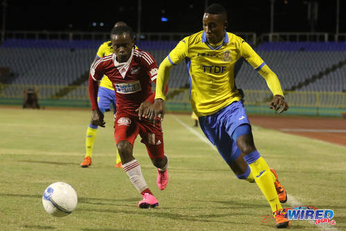 Photo Defence Force winger Ross Russell Jr (right) hustles past Central FC midfielder Darren Mitchell during 2015/16 Pro League action at the Hasely Crawford Stadium. (Courtesy Chevaughn Christopher/Wired868)