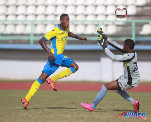 Photo: Defence Force winger Ross Russell Jr (left) lifts the ball over Police FC custodian Perry O'Connor for his team's third goal in 2015/16 Pro League action in Malabar on 26 January 2016. (Courtesy Nicholas Bhajan/Wired868)