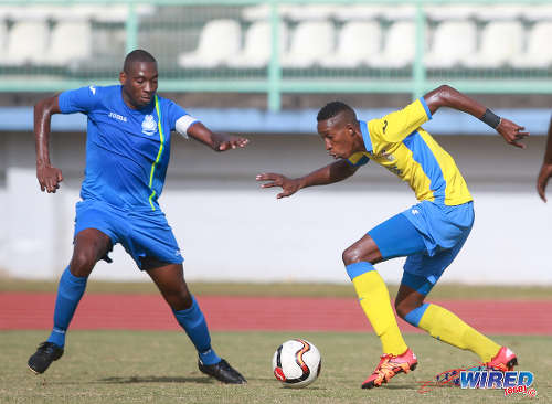 Photo: Defence Force winger Ross Russell Jr (right) tries to sneak past Police FC midfield sentry Todd Ryan during 2015/16 Pro League action in Malabar. (Courtesy Nicholas Bhajan/Wired868)