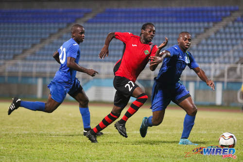 Photo: San Juan Jabloteh winger Nathan Lewis (centre) terrorises the Police FC defence during 2015/16 Pro League action in Couva. (Courtesy Chevaughn Christopher/Wired868)