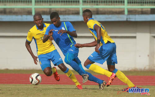 Photo: Police FC attacker Kareem Freitas (centre) tries to escape from Defence Force players Ross Russell Jr (right) and Akile Edwards during 2015/16 Pro League action in Malabar. (Courtesy Nicholas Bhajan/Wired868)