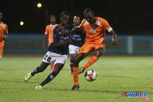 Photo: Club Sando midfielder Jared London (right) holds off Morvant Caledonia United attacker Pernell Schultz during 2015/16 Pro League action at the Ato Boldon Stadium, Couva. (Courtesy Chevaughn Christopher/Wired868)