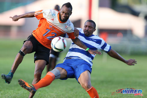 Photo: Former Trinidad and Tobago attacker Gary Glasgow (left) tries to avoid a tackle from Wired868 XI left back Gregory Seale during the 4th Annual Wired868 Football Festival at UWI SPEC Grounds, St Augustine. (Courtesy Allan V Crane/CA-images/Wired868)