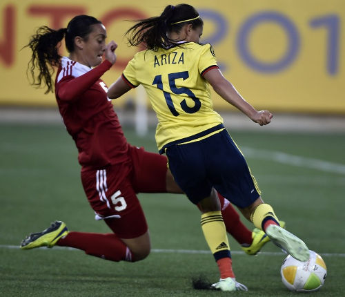 Photo: Trinidad and Tobago defender and 2014 TTFA Player of the Year Arin King (left) dives in to tackle Colombia's Tatiana Ariza during the Toronto 2015 Pan American Games. (Copyright AFP 2016)