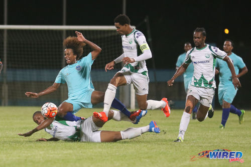 Photo: Atlantico FC winger Bryan Gonzales (second from left) is chopped down by a tackle from W Connection midfielder Briel Thomas (left) while Gerard Williams (far right) and Alvin Jones look on during 2016 Caribbean Club Championship action last night in Couva. (Courtesy Chevaughn Christopher/Wired868)