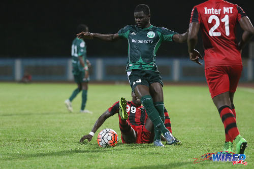 Photo: W Connection midfielder Hughtun Hector (centre) glides past fallen Inter Moengo Tapoe midfielder Naldo Kwasie during CFU Caribbean Club action at Couva on 28 February 2016. (Courtesy Chevaughn Christopher/Wired868)