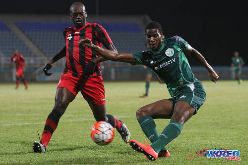 Photo: W Connection left back Kurt Frederick (right) crosses the ball past Inter Moengo Tapoe defender Jürmen Vallei to set up the opening goal during CFU Caribbean Club action at Couva on 28 February 2016. (Courtesy Chevaughn Christopher/Wired868)