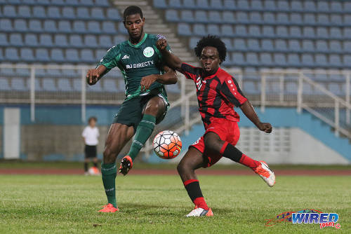 Photo: W Connection left back Kurt Frederick (left) tackles Inter Moengo Tapoe attacker Romeo Kastiel during CFU Caribbean Club action at Couva on 28 February 2016. (Courtesy Chevaughn Christopher/Wired868)