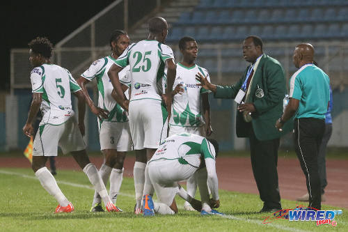 Photo: W Connection coach Stuart Charles-Fevrier (second from right) and assistant coach Earl Jean (far right) speak to their players during a break between the action against Atlantico FC in 2016 Caribbean Club Championship action last night. (Courtesy Chevaughn Christopher/Wired868)