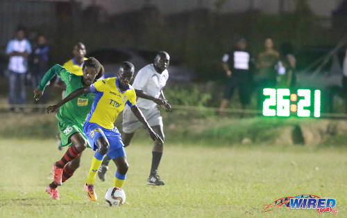 Photo: San Juan Jabloteh midfielder Marvin Oliver (left) chases Defence Force captain Jerwyn Balthazar (centre) while referee Gyasi McDonald looks on during Pro League action on 12 March 2016 at the Barataria Recreation Ground. (Courtesy Nicholas Bhajan/Wired868)