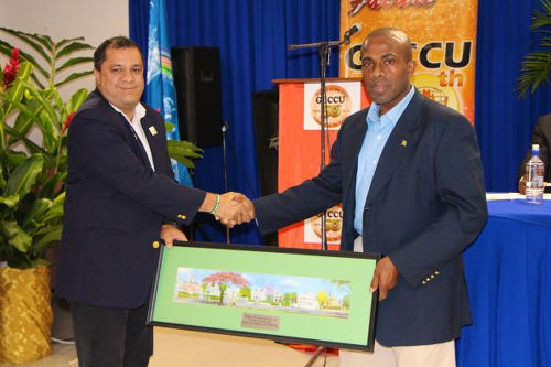 Photo: COPOS Credit Union manager and Trinidad and Tobago Gymnastics Federation (TTGF) president David Marquez (left) makes a presentation to GECCU president Clarence Harry. (Copyright GECCU)