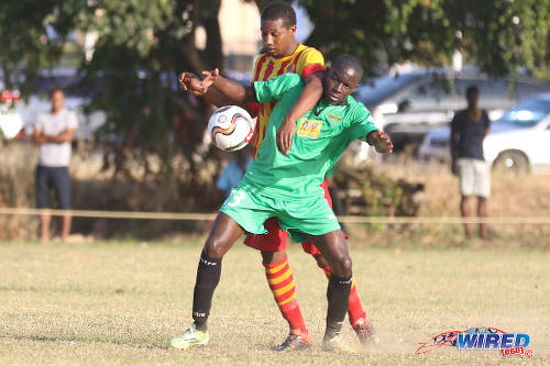 Photo: San Juan Jabloteh playmaker Fabian Reid (right) tries to hold off a Point Fortin Civic player during TT Pro League action at the Barataria Recreation Ground, Barataria on 5 March 2016. (Courtesy Chevaughn Christopher/Wired868)