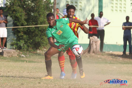 Photo: San Juan Jabloteh forward Jamal Gay (foreground) tries to hold off a Point Fortin Civic opponent during TT Pro League action at the Barataria Recreation Ground, Barataria on 5 March 2016. (Courtesy Chevaughn Christopher/Wired868)