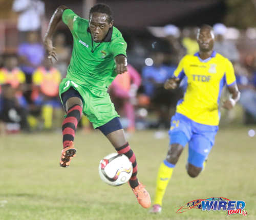 Photo: San Juan Jabloteh winger Nathan Lewis (left) smashes home his double while Defence Force left back Akile Edwards looks on during Pro League action on 12 March 2016 at the Barataria Recreation Ground. (Courtesy Nicholas Bhajan/Wired868)